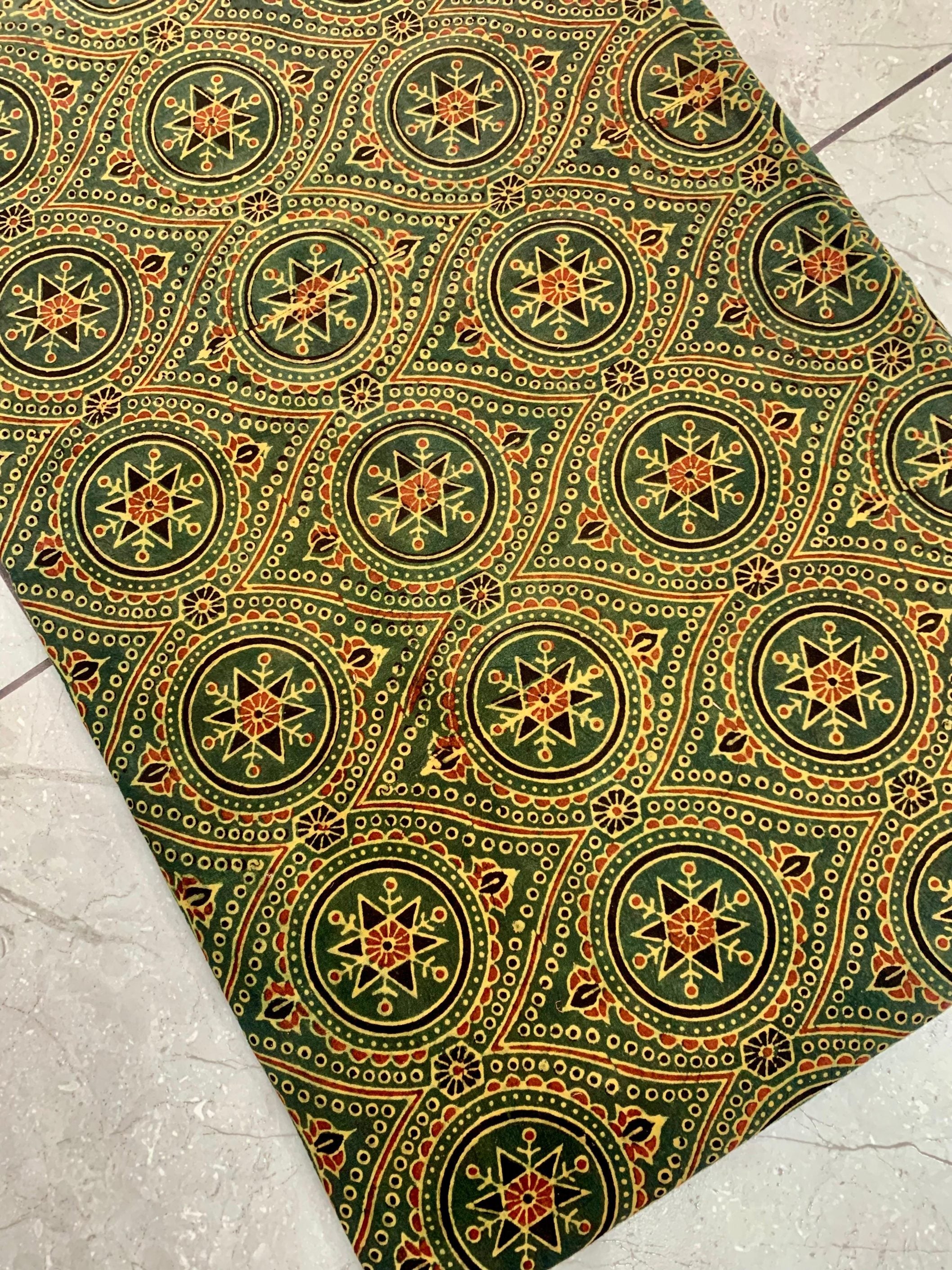 Green pure cotton Ajrakh fabric wholesale featuring heritage geometric patterns handprinted using natural dyes.